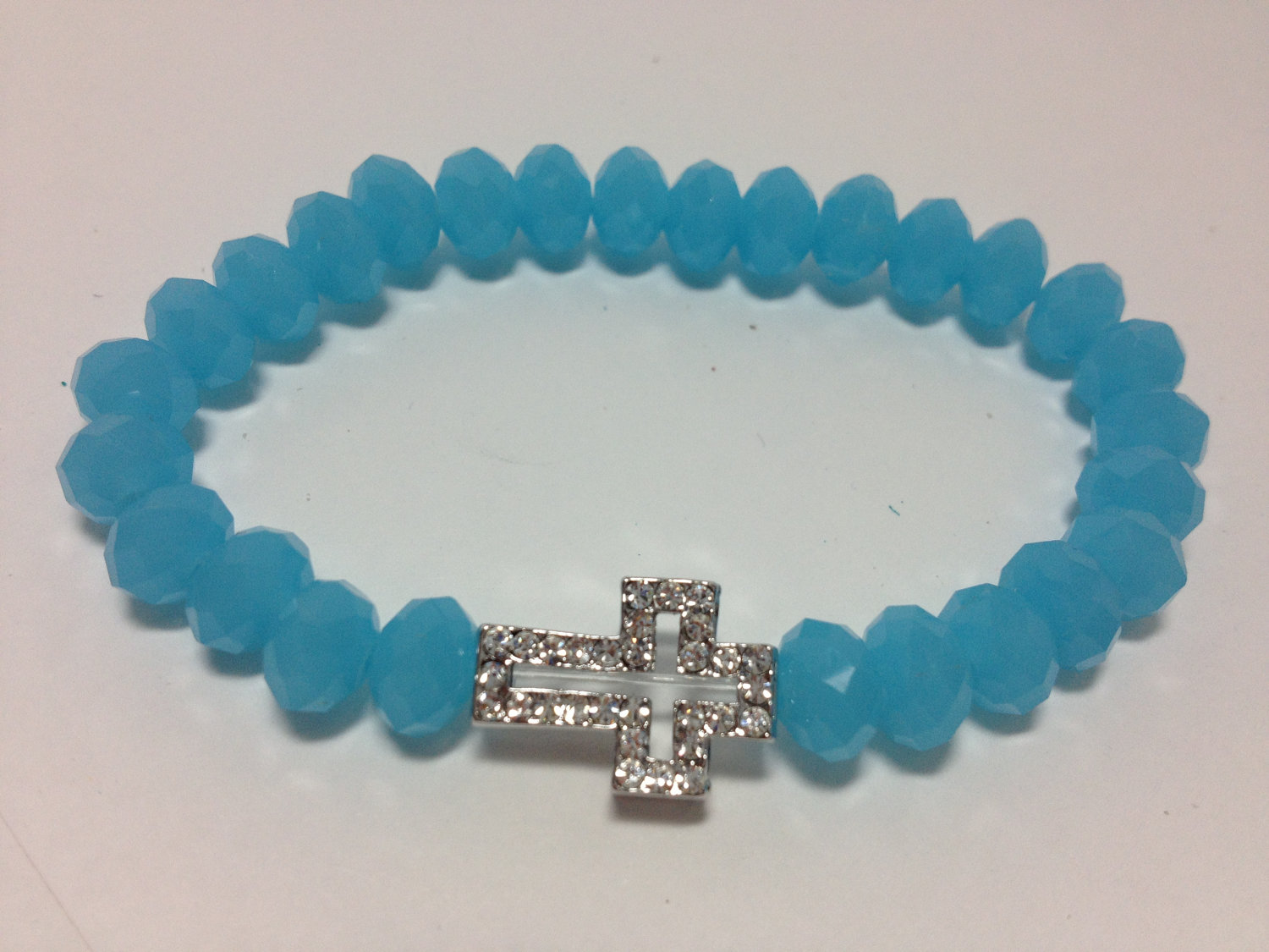 Crystal pave cross with light blue rondelle beads